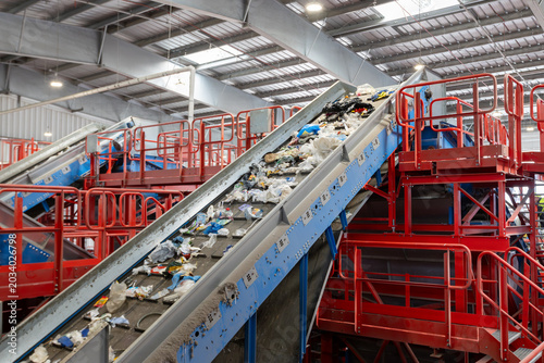 Foto Waste conveyor belt with mixed garbage moving through recycling sorting line