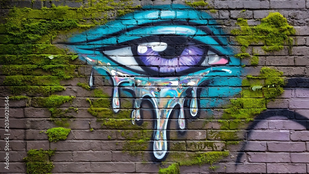 Fototapeta premium Crying eye graffiti on a brick wall