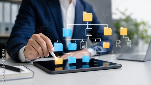 Business professional organizing digital file folders on virtual interface using a stylus portrays modern data management and document classification efficiency