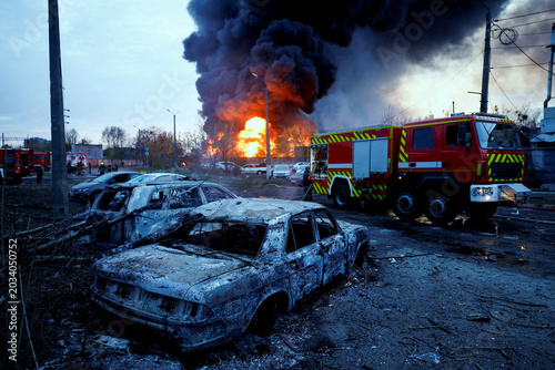 Obraz na plátne Firefighters work next to destroyed and burned vehicles at the site of a Russian