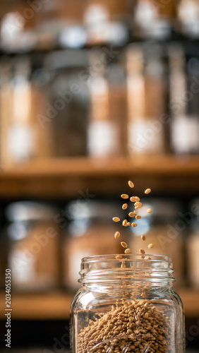 Vertical Macro Shot of Dry Grains Falling into Glass Jar at Refill Station