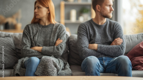 Frustrated couple avoiding eye contact during relationship conflict at home with emotional tension and divorce concept