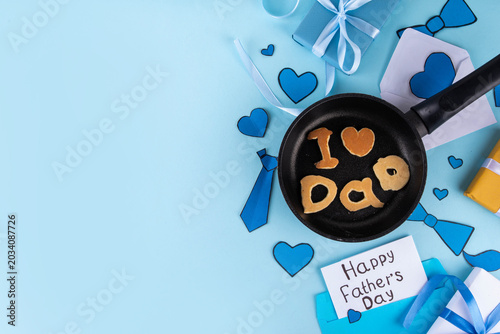 Father's day holiday idea for morning surprise gift with pancakes. Father Day breakfast or brunch. Child preparing food for dad, creatively made pancakes with inscription I love Dad, Best dad ever