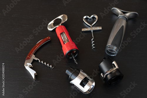 Tableau sur toile Sommelier kit includes waiter corkscrew and  vacuum stopper, sommelier tool selection displayed on elegant black background, sommelier accessory set makes perfect gift for wine enthusiast