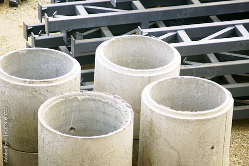 Tableau sur toile Close-up of precast concrete utility shaft cylinders positioned beside structural frames