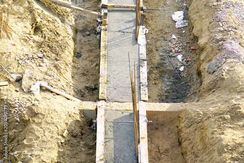 Fényképezés Narrow poured concrete corridor extending through excavated earth cut at active civil engineering site