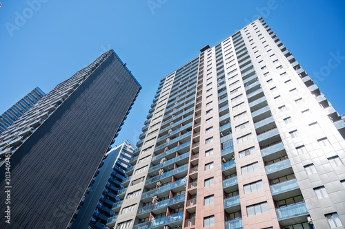 Modern high-rise residential buildings with new facades against a clear blue sky.