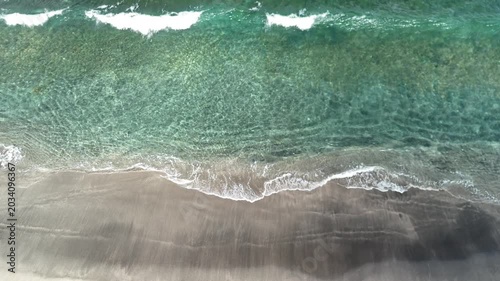Slow Motion Aerial View of Gentle Ocean Waves Crashing on Sandy Beach