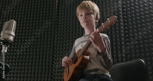 Boy Play Music on Ukulele Instrument in Home Studio. 4K 10-bit