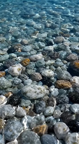 Tranquil underwater pebbles with moving caustic light patterns in seamless cinematic natural loop