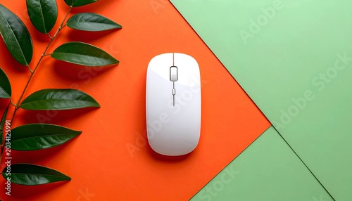White computer mouse on an orange and green geometric background with a leafy branch