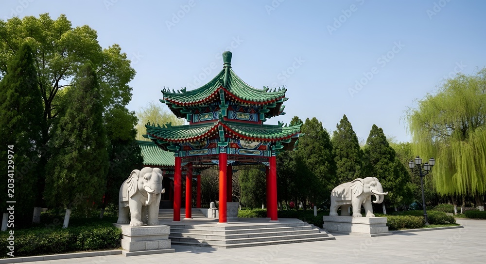 Fototapeta premium A beautiful traditional Chinese pavilion with a green roof and red pillars stands with elephant statues