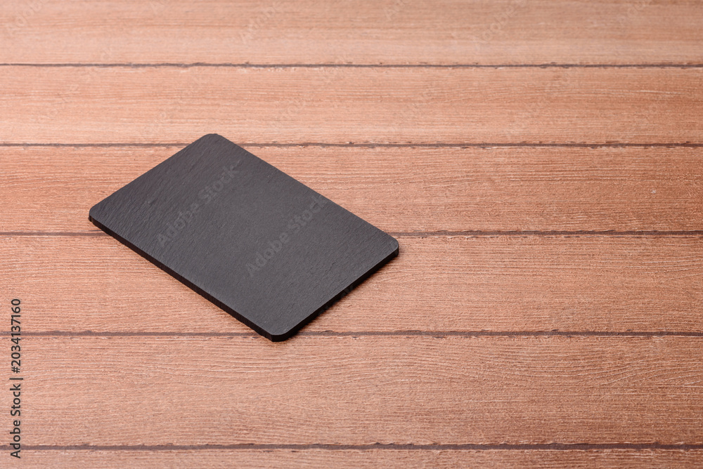 Fototapeta premium An empty slate cutting board for preparing ingredients for home cooking. An empty cutting board