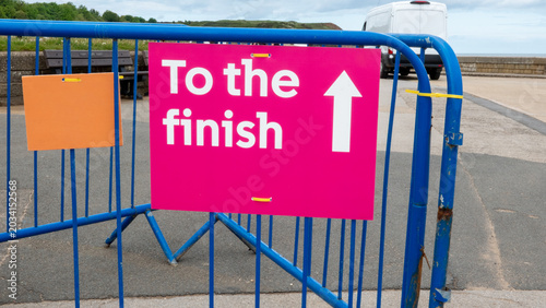 Pink “To the Finish” Sign on Metal Barrier
