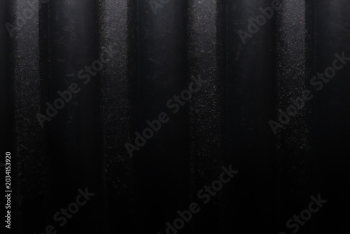 Macro shot of grey flexible corrugated PVC pipe surface. Abstract industrial background of plastic conduit or flexible hose with parallel vertical ribs for cable protection and construction concepts.