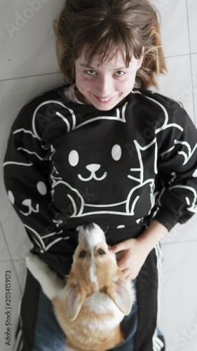 A playful Pembroke Welsh Corgi puppy happily spends time with a child at home, displaying friendliness, fun, and warmth in a cozy home environment. Pet concept.