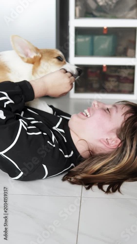 A playful Pembroke Welsh Corgi puppy happily spends time with a child at home, displaying friendliness, fun, and warmth in a cozy home environment. Pet concept.
