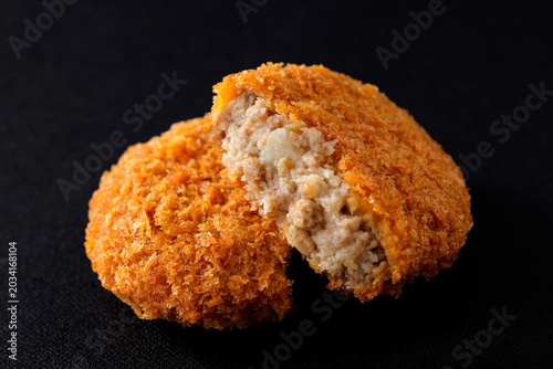 黒背景に映えるサクサクした衣の揚げ立て牛肉コロッケ　Crispy fried beef croquettes on a black background