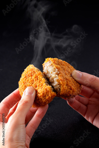 手で割った揚げ立てのサクサク牛肉コロッケ　 Crispy fried beef croquette being broken open by hand