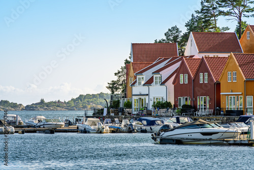 Southern Norway waterfront living with marina boats, seaside houses and calm harbor atmosphere near Lindesnes Lighthouse for Nordic travel, coastal housing and local tourism