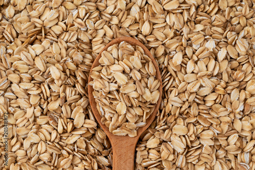 Photos Raw oat groats with wooden spoon – healthy eating concept