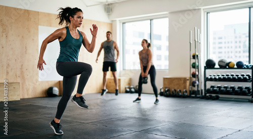 Group of people doing HIIT workout in gym. Fitness and weight loss training concept