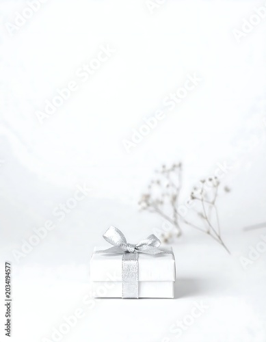 Minimal White Gift Box Wrapped with Silver Ribbon on Soft White Background