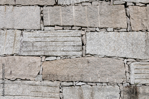 Fotografie Background of a granite ashlar wall with dry stone construction technique