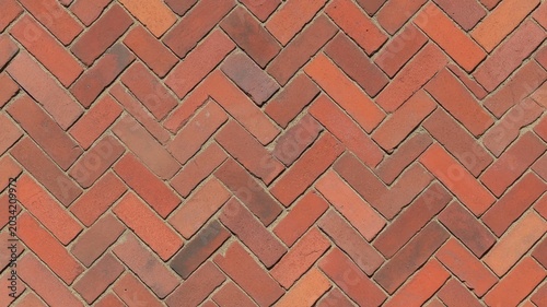Rustic red herringbone brick pavement pattern background texture design surface backdrop.