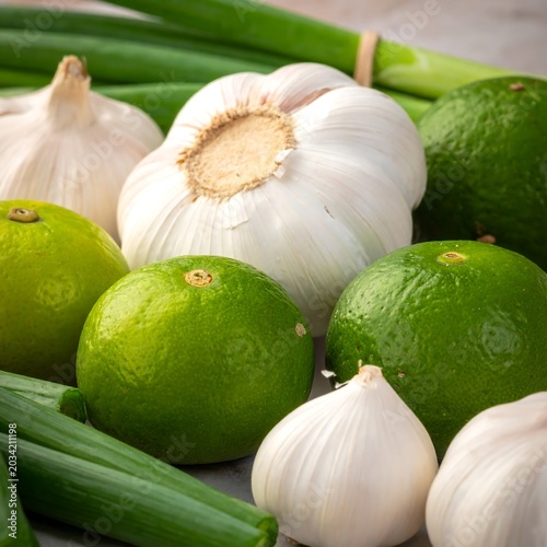 Fresh green limes, garlic, and green onions