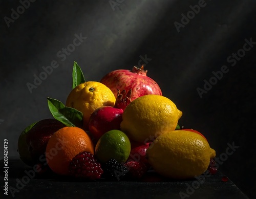 Colorful Fresh Citrus and Pomegranate Arranged in Dramatic Dark Studio Still Life