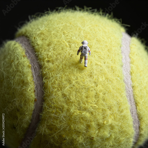 Tiny Astronaut Walking on the Fuzzy Yellow Surface of a Tennis Ball, Surreal Sci-Fi Scale Macro Texture