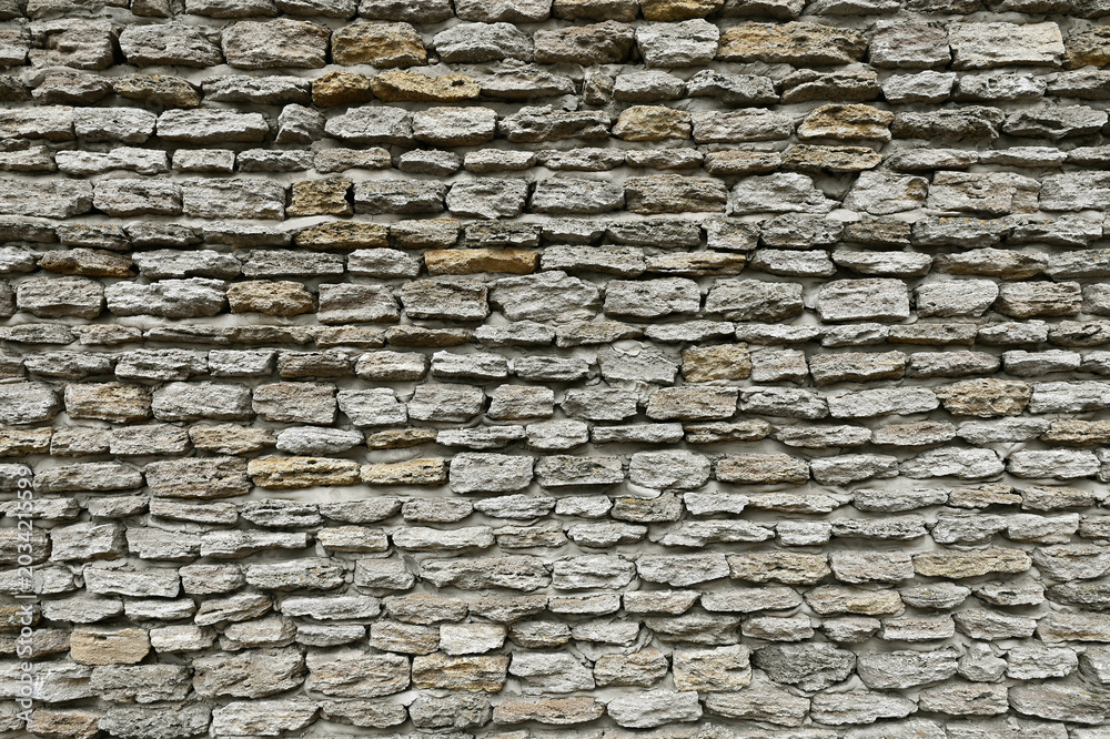 Fototapeta premium Full frame texture of old rustic stone wall built from rough natural limestone blocks