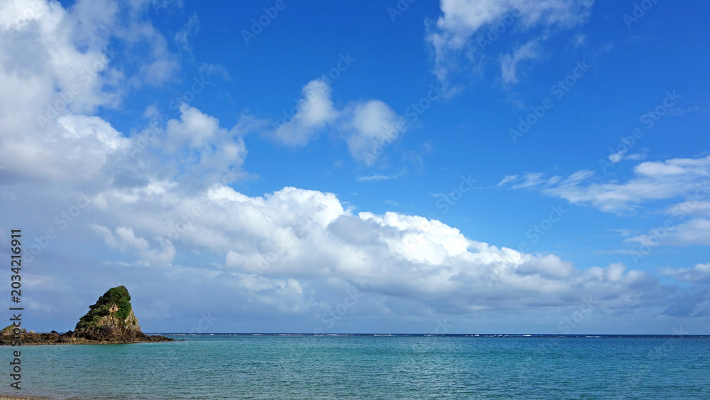 Obraz premium 沖縄の青い海と空に浮かぶ白い雲の風景 嘉陽ビーチ やんばる