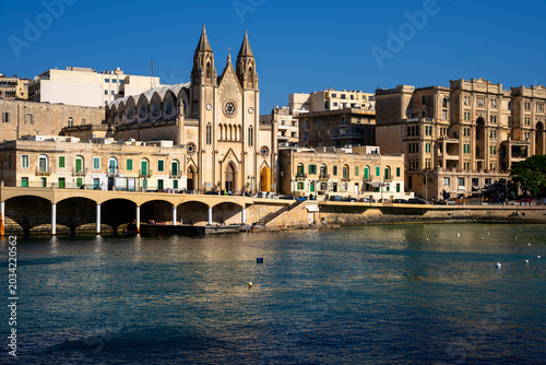 Tableau sur toile Neo Gothic Carmelite Church at Balluta Bay waterfront promenade in St Julians, M