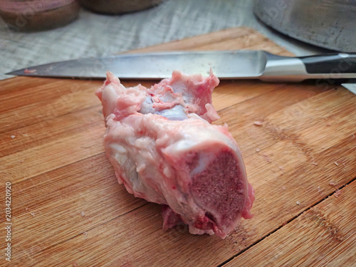 Raw Piece of Meat with Bone on Cutting Board