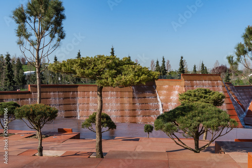 Canyon, water amphitheater feature consisting of series of terra-cotta colored walls with flowing water cascading down their surfaces. Krasnodar, Galitsky Park. Cloud Park