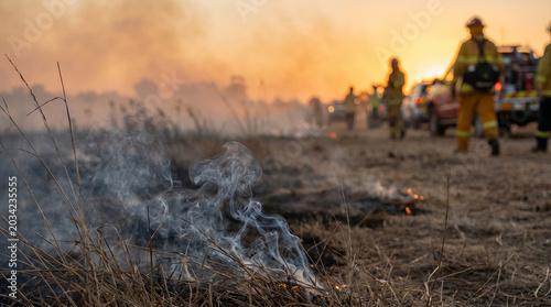 Firefighters battling wildfire smoke at sunset during natural disasters  