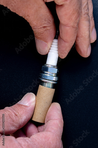 Mechanic removes cardboard tube from sparkplug