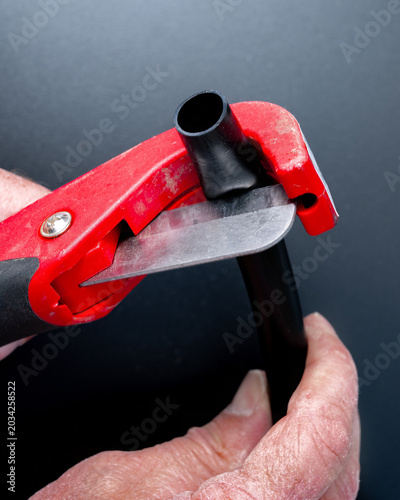 Irrigation tube cutter with red handle closeup