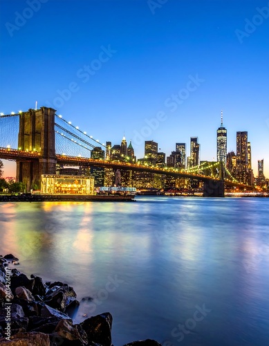 Iconic bridge illuminated against city skyline at dusk