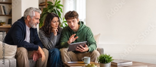 Family discussing finance together on tablet at home with plants in background