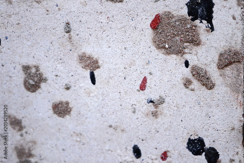 Bild auf Leinwand Pale Weathered Concrete Surface with Sand Clumps and Scattered Black Red Paint S