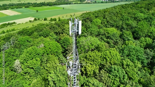 Cellular Communication Tower Above Dense Green Forest Landscape