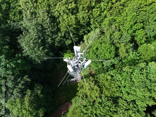 Cellular Communication Tower Above Dense Green Forest Landscape