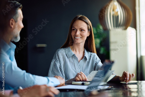 Fotografía Happy entrepreneur talking to her colleagues during business meeting in office