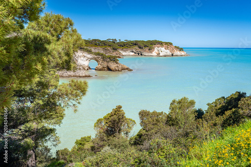 The famous San Felice natural arch rises above turquoise waters along the Gargano Italian coastline.