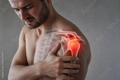 Man clutching his painful shoulder with a highlighted joint and skeleton