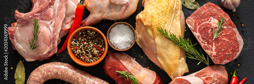 Foto Different types of meat are spread out on a dark surface