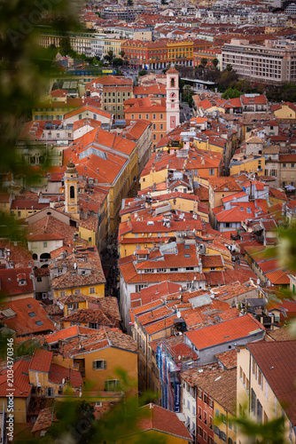 Aerial panoramic view over the terracotta rooftops of the historic old town of Nice with the Mediterranean Sea in the background on a sunny day